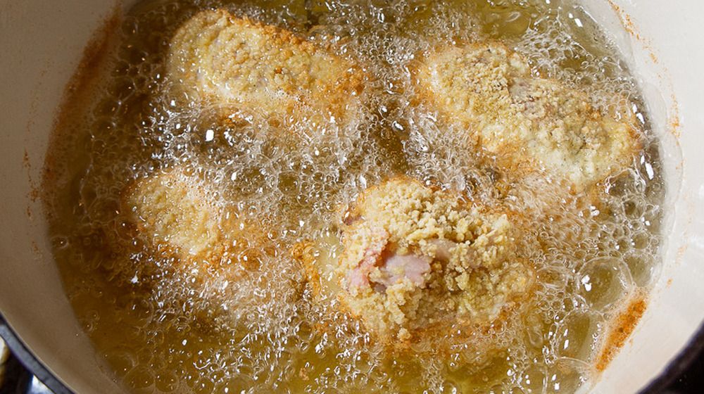 鶏肉の炒め物が入った熱い油の鍋