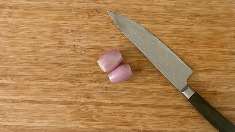   szalotki i nóż na desce do krojenia