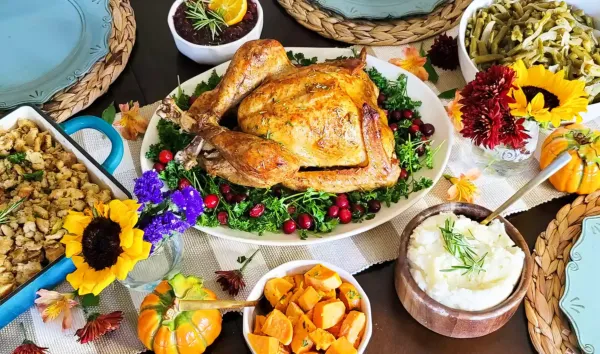 サツマイモ、詰め物、マッシュポテト、インゲン、七面鳥の感謝祭の食事がセットされたテーブルセット。