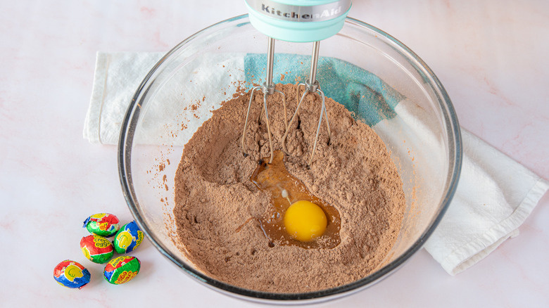  乾燥したキャドバリー・クリーム・エッグ・カップケーキの材料に卵を加える