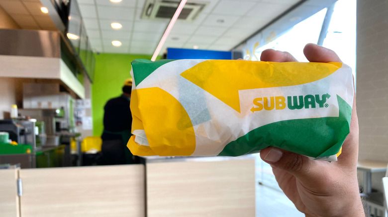 Podnoszenie kanapki Subway w pustym sklepie