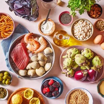 grupa produktów diety śródziemnomorskiej obejmująca stek, krewetki, jagody, karczochy, jogurt, nasiona, makaron, orzechy, jajka i oliwę z oliwek